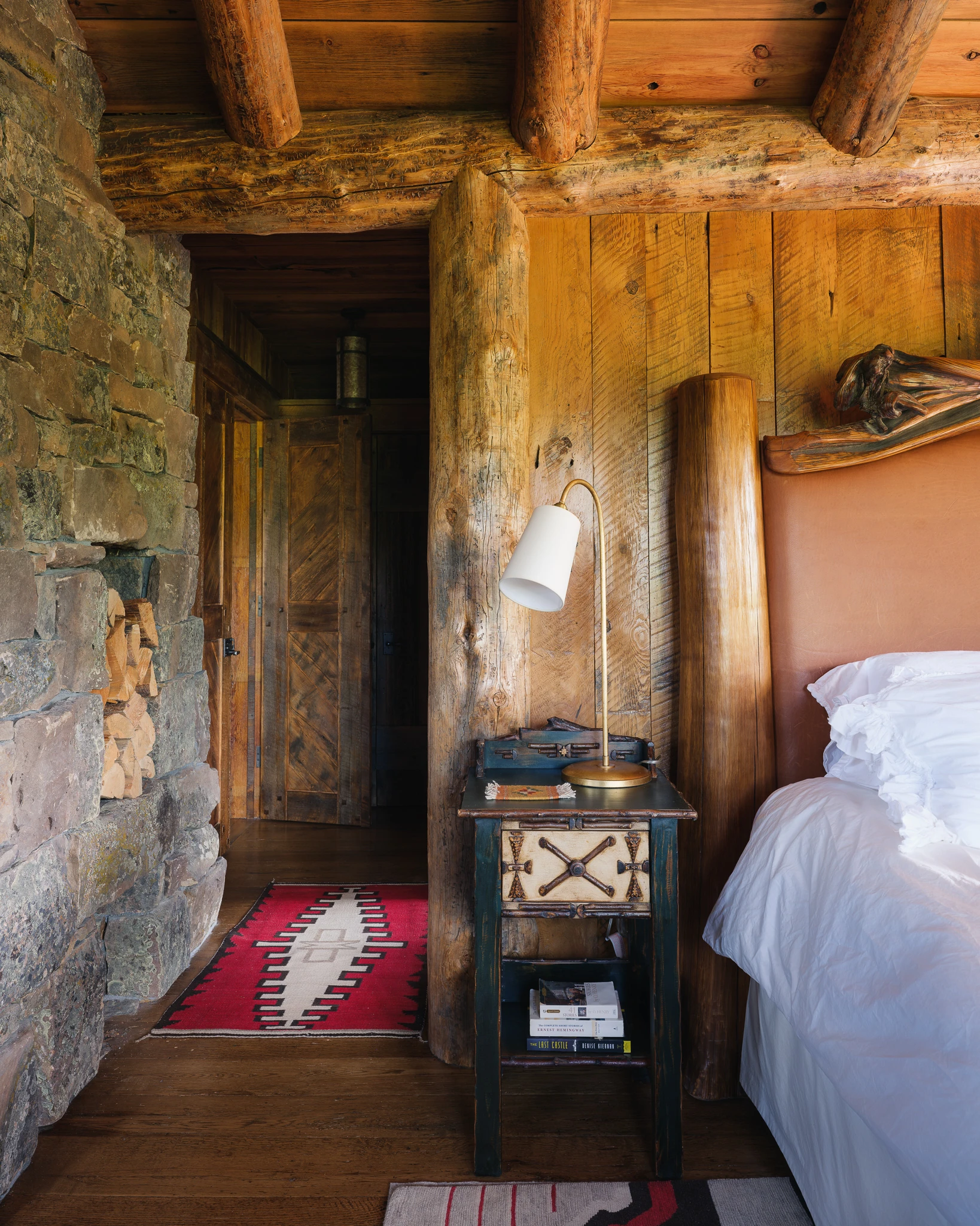 Bedside detail against reclaimed log wall — interior design photography Big Sky Montana, Club Ridge